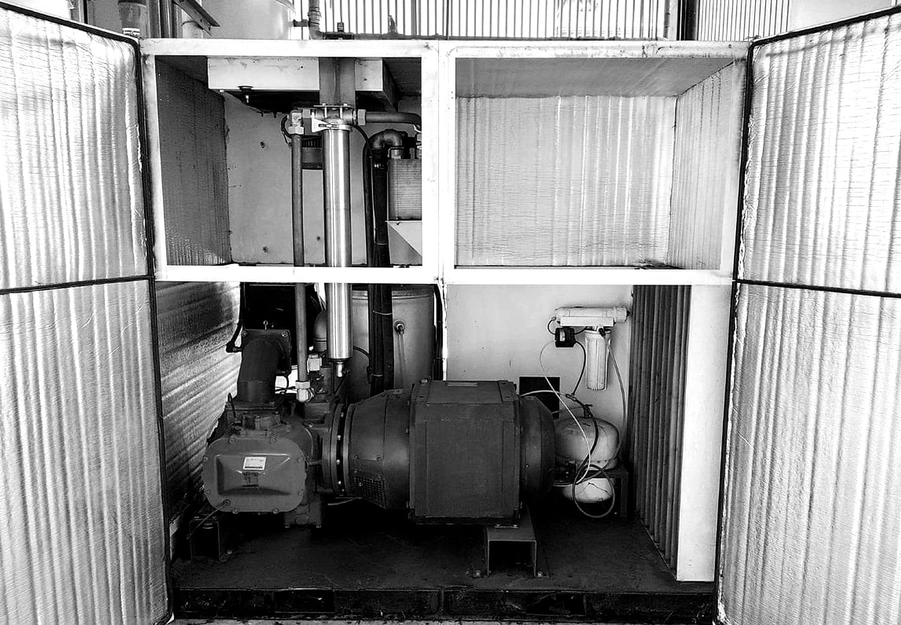 Industrial compressor installed on site with the enclosure doors open